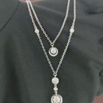 Load and play video in Gallery viewer, Video showcasing the 0.36 CT natural round cut diamond double layered pendant set in 18kt white gold, highlighting the elegant two-layer design and the brilliant sparkle of the round diamonds from a detailed close-up.
