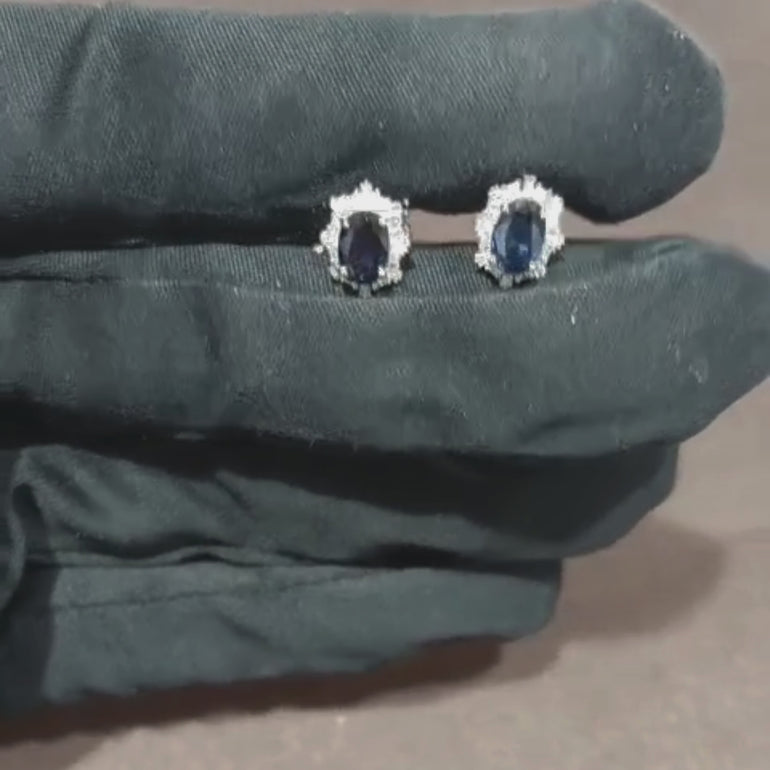 Video showcasing the 0.33 CT natural princess and tapered baguette cut diamond stud earrings with oval blue sapphire accents, set in 18kt white gold, highlighting their elegant sparkle and vibrant color contrast.