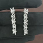 Load and play video in Gallery viewer, Video showcasing the 1.68 CT natural round and tapered baguette cut diamond drop earrings set in 18kt white gold, highlighting their elegant design and brilliant diamond sparkle.
