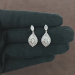 Load and play video in Gallery viewer, Video showcasing the 0.92 CT natural round, princess, and tapered baguette cut diamond drop earrings set in 18kt white gold, highlighting their exquisite design and brilliant diamond sparkle.
