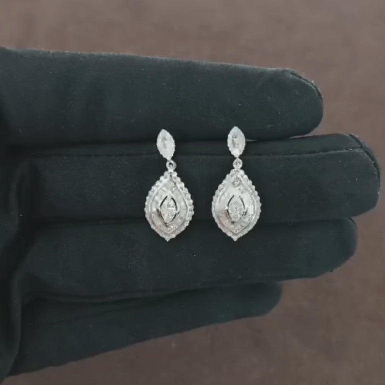 Video showcasing the 0.92 CT natural round, princess, and tapered baguette cut diamond drop earrings set in 18kt white gold, highlighting their exquisite design and brilliant diamond sparkle.
