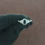 Load and play video in Gallery viewer, Video showcasing the 0.43 CT natural round and tapered baguette cut diamond ring with an oval blue sapphire, set in 18kt white gold, highlighting the sparkling diamonds and vibrant sapphire in an elegant design
