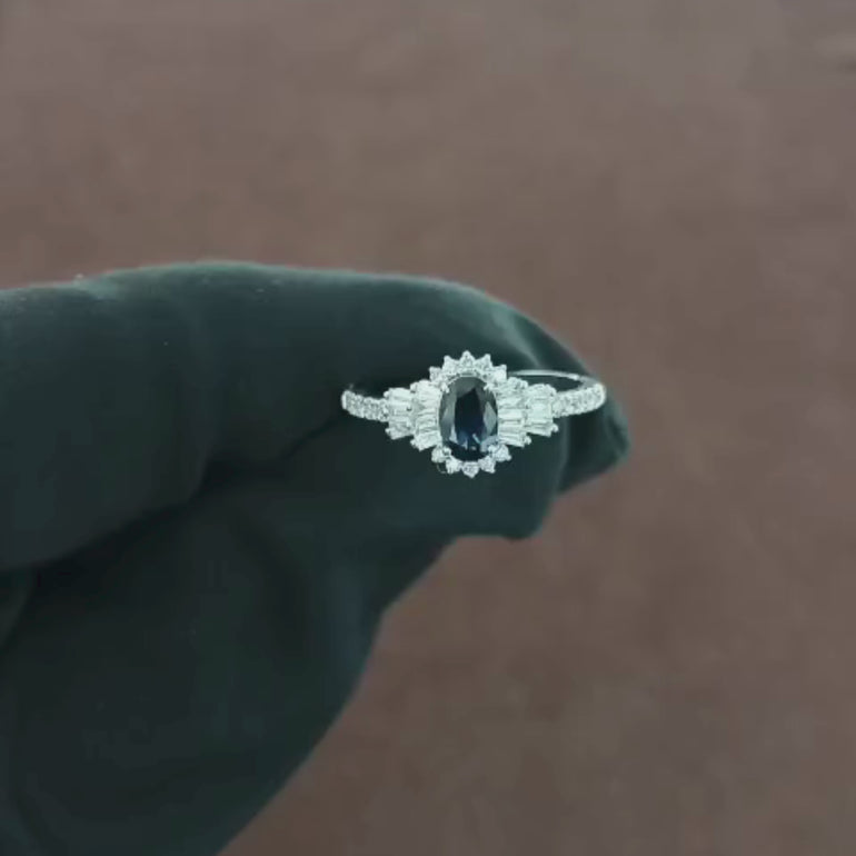 Video showcasing the 0.43 CT natural round and tapered baguette cut diamond ring with an oval blue sapphire, set in 18kt white gold, highlighting the sparkling diamonds and vibrant sapphire in an elegant design