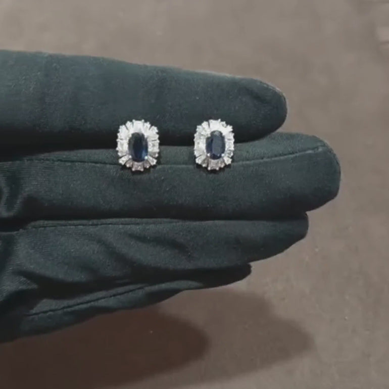 Video showcasing the 0.75 CT natural princess and tapered baguette cut diamond earrings with blue sapphire accents, set in 18kt white gold, highlighting their brilliant sparkle and vibrant color contrast.