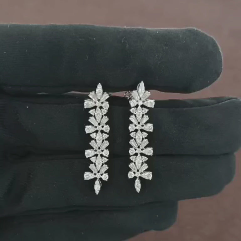 Video showcasing the 1.58 CT natural round and tapered baguette cut diamond drop earrings set in 18kt white gold, highlighting their stunning design and brilliant diamond sparkle.